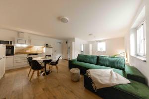 Staudach-EgerndachにあるFerienwohnung Siebenschläferの緑のソファとテーブルのあるリビングルーム