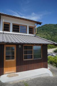 a house with a metal roof on top of it at Yugashira Kuu ゆがしら空 in Imabari