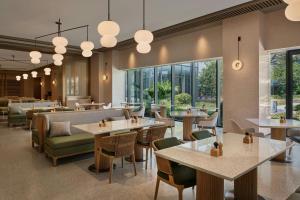 蘇州市にあるSuzhou Marriott Hotel Yangcheng Lakeのテーブルと椅子と窓のあるレストラン