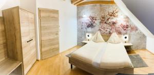 a bedroom with a bed and a painting on the wall at Ferienhof Uhudler-Arkaden in Stegersbach +79 photos