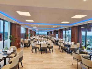 a restaurant with tables and chairs and windows at Glam Hotel Nairobi - Near Westgate Mall, Westlands in Nairobi
