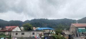 a group of buildings with mountains in the background at Blessed guest Nuwara eliya in Nikawatawana