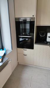 a kitchen with a black oven and white cabinets at Villa AIMÉ SALMCHÂTEAU in Vielsalm