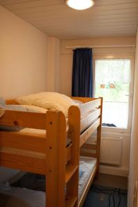 ブラズィリアンにあるFerienwohnung F127 an der Ostseeの二段ベッドと窓のある寝室 +4枚の写真