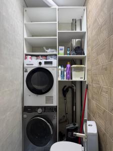 een wasmachine en droger in een kleine kamer bij TaTa Guest House in Bisjkek