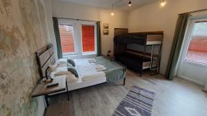 a bedroom with a bed and a desk and a bed and a piano at Zamárdi Trafóház in Zamárdi