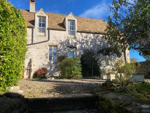 an old stone house with a driveway in front of it at Gîte Laure et Henri in Ladoix Serrigny