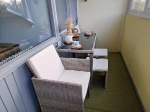 ブラズィリアンにあるFerienwohnung S249のバルコニー(椅子、テーブル付)、窓が備わります。