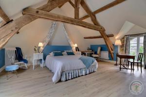 ein Schlafzimmer mit einem Bett in einem Zimmer mit Holzböden in der Unterkunft La bremande in Saint-Georges-de-Reintembault