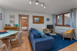 a living room with a blue couch and a table at Maison à Tour Briançon in Briançon