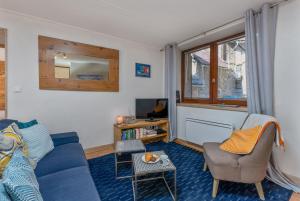 a living room with a blue couch and a chair at Maison à Tour Briançon in Briançon