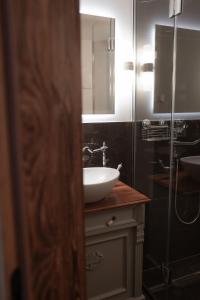 a bathroom with a white sink and a shower at Löw Chalet Suite 2, Steps from the Slopes by 360 Estates in Kitzbühel