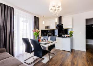 a kitchen and living room with a table and chairs at Sunrise Apartaments in Rowy