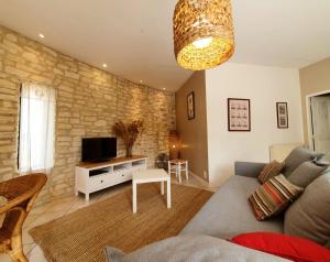 a living room with a couch and a tv at Côté Provence in Le Thor