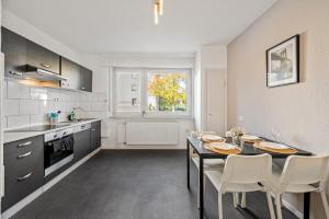a kitchen with a table and chairs in a room at BIR02 Wohnung mit Garten in Rüsselsheim! in Rüsselsheim