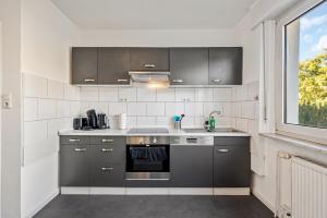 a kitchen with stainless steel appliances and a window at BIR02 Wohnung mit Garten in Rüsselsheim! in Rüsselsheim