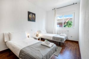 ein Schlafzimmer mit zwei Betten und einem Fenster in der Unterkunft Bonita casa en Torrejón del Rey in Torrejón del Rey