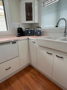 een keuken met witte kasten en een spoelbak bij Seashells of Seaforth in Seaforth