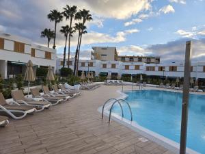 Una piscina con tumbonas y un hotel. en Las Brisas Canary Home Rent, en San Bartolomé