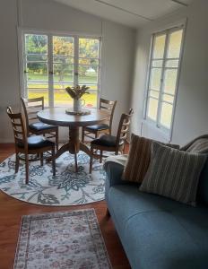 een woonkamer met een bank, een tafel en stoelen bij Seashells of Seaforth in Seaforth
