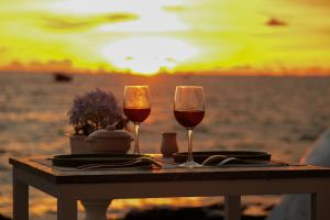 two glasses of wine sitting on a table at the beach at Coastal Homestay Phu Quoc in Phu Quoc +26 photos