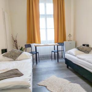 a room with two beds and a table and a window at Ubytování blízko národního muzea A1 in Prague