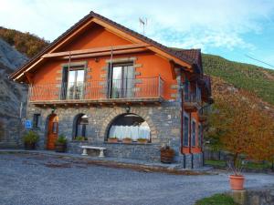 an orange house with a balcony on the side of it at Casa Miguel Périz in Sorripas