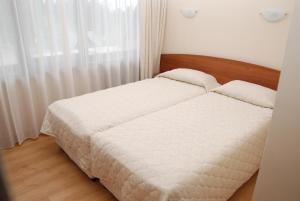 une chambre avec un lit avec des draps blancs et une fenêtre dans l'établissement Borovets Snow Hotel, à Borovets