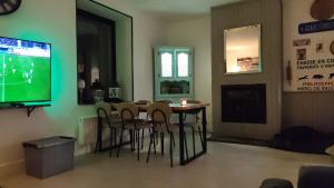 a dining room with a table and chairs and a television at Villa AIMÉ SALMCHÂTEAU in Vielsalm
