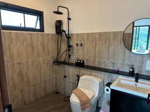 a bathroom with a toilet and a sink and a mirror at PASSA ผัสสะ Tea Plantation @Mae On in Ban Huai Kaeo +41 photos