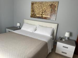 a bedroom with a white bed with two night stands and two lamps at B&B IL QUADRIFOGLIO in Iesi
