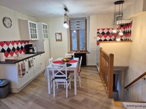 a kitchen and dining room with a table and chairs at Le logis du Colombier in Culoz