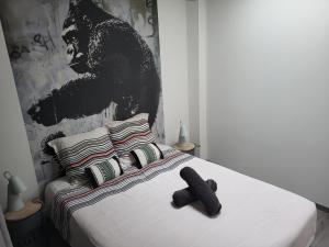 a black teddy bear sitting on a white bed at Levogien in Hagécourt
