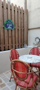 a table and chairs with a sign on a fence at PARIS AUTHENTIC HOUSE open space studio Métro 14 Hôpital Bicêtre, RER B Gentilly in Gentilly