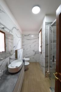 Dos lavabos en un baño con paredes de mármol. en A Dream in Tuscany, en Montespertoli