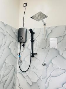 a shower in a bathroom with a black hose at Bosilu Villa in Weligama