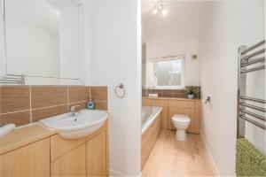 Un baño con lavabo, inodoro y bañera. en Aberdeen 2BR Flat Near Airport & City Centre, en Aberdeen