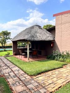 a hut with a table and chairs in a yard at Marjaniek Wedding Venue & Guest House in Rietfontein +130 photos