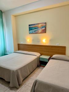a room with two beds and a painting on the wall at Hotel Valente in Ortona