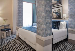 a hotel room with a bed and a window at NH Collection Colón Valencia in Valencia