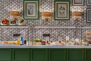 a buffet with fruits and plates of food on a counter at NH Collection Colón Valencia in Valencia