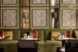 a dining room with two tables and two windows at NH Collection Colón Valencia in Valencia +47 photos