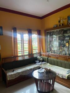 a living room with two beds and a table at Sebastian Homes in Madikeri