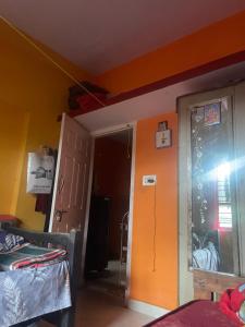 a room with an orange wall and a door at Sebastian Homes in Madikeri