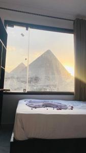 a bedroom with a view of a mountain through a window at Hany pyramids view in Cairo