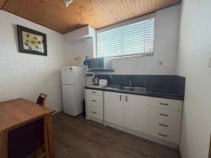 a kitchen with a white refrigerator and a sink at Cod Place in Beautiful South West Rocks in South West Rocks