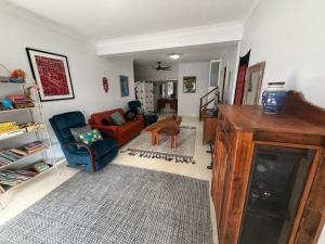 a living room with a red couch and a chair at Cod Place in Beautiful South West Rocks in South West Rocks