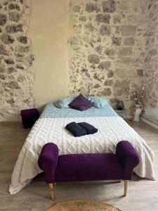- une chambre avec un lit doté d'oreillers violets dans l'établissement Studio cosy en pierre au cœur du vieux Langon, à Langon
