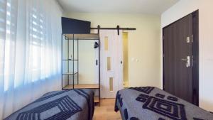 a bedroom with two beds and a window and a door at MILITARY Guest Inn in Drawsko Pomorskie