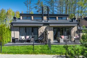 une maison avec un porche et des chaises dans la cour dans l'établissement Žalia kopa near the beach apartments, à Palanga